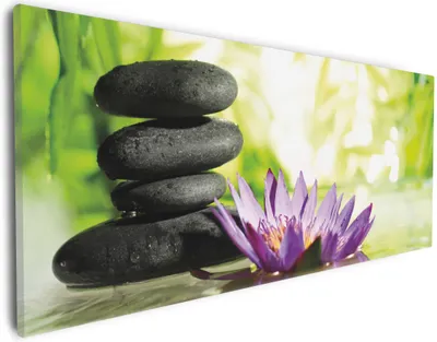 Produktbild von Wallario Premium Leinwandbild Steinstapel in schwarz mit Blumenblüte in lila in Größe 30 x 75 cm