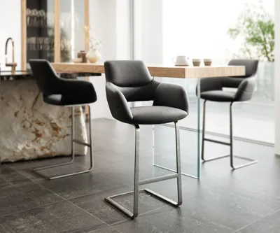 A modern dining area with bar stools and a table.