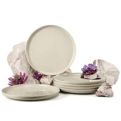 A set of beige plates arranged with rocks and artificial succulents.
