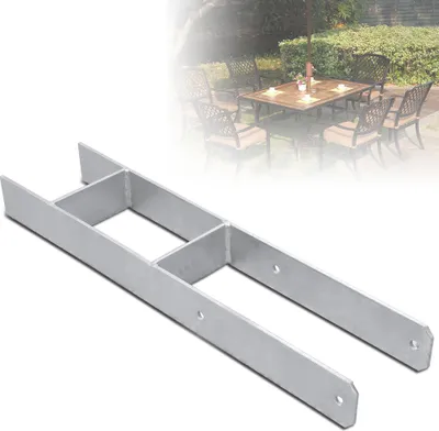A metal H-shaped bracket for fence posts, with a blurred background of an outdoor dining set.