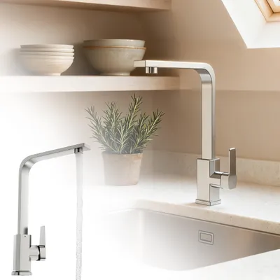 A modern kitchen sink with a chrome faucet and a potted rosemary plant on the counter.