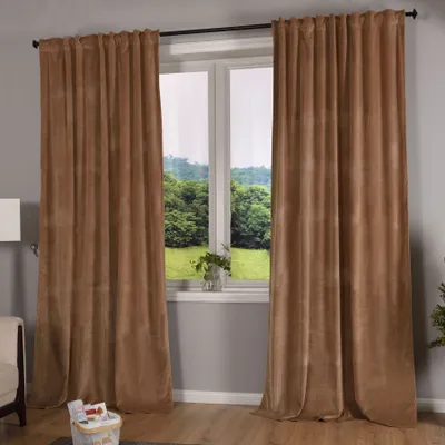 A room interior with large brown velvet curtains covering a window, with a view of greenery outside.