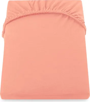 A close-up, top-down view of a peach-colored fitted sheet.