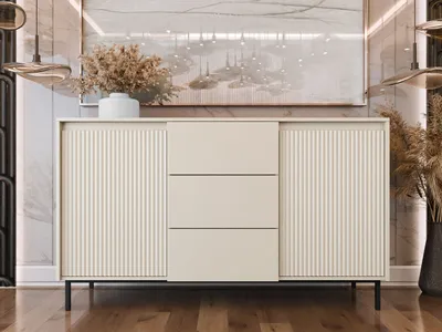 A modern sideboard with fluted doors and drawers, set against a marble-patterned wall with abstract art above.