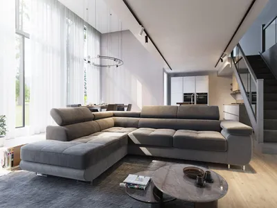 A modern living room with a large sectional sofa, coffee table, and stairs leading to an upper level.