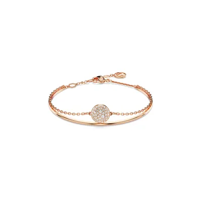 A rose gold bracelet with a circular, crystal-embellished charm.