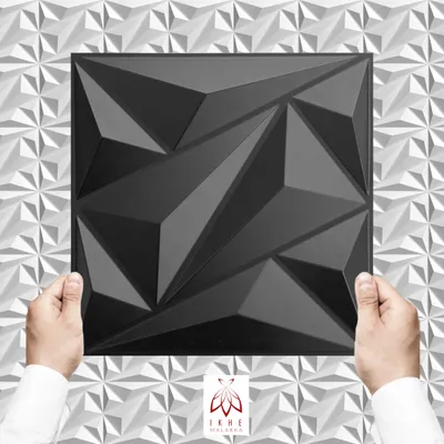 Hands holding a black 3D wall panel against a white geometric background.