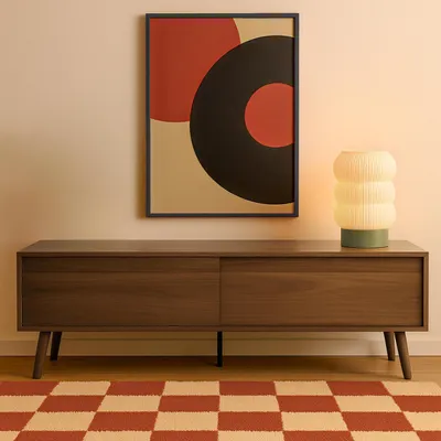 A modern living room scene featuring a TV cabinet, artwork, and a lamp.