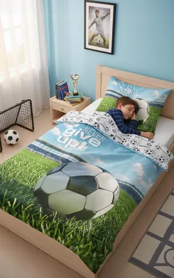 A child sleeping in a bed with soccer-themed bedding.
