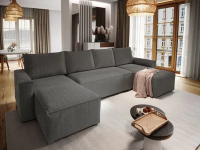 A modern living room with a large sectional sofa, coffee table, and decorative elements.