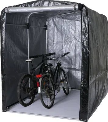 Two bicycles are stored inside a black tarp garage.