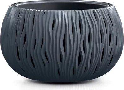 A dark gray, round planter with a wavy, cut-out pattern sits on a white surface.