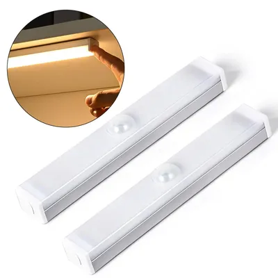 Two white LED light bars with motion sensors are shown on a white background. A circular inset shows a hand touching a similar light bar mounted under a shelf, illuminating it.