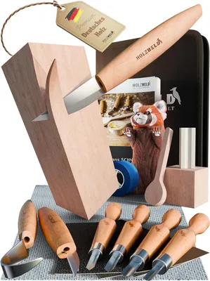 A collection of wood carving tools and materials, including a knife, chisels, wood blocks, and a red panda carving.