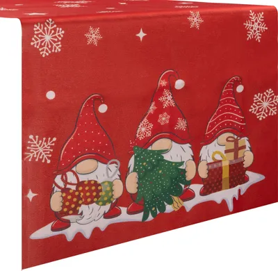 A close-up view of a red Christmas table runner featuring three gnomes holding gifts and a Christmas tree, with snowflakes scattered across the background.