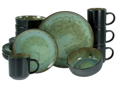 A collection of stoneware dishes and mugs with a green and black glaze.