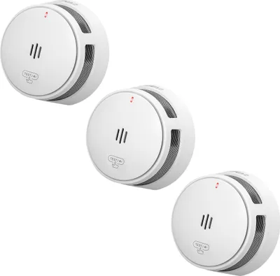 Three white smoke detectors are arranged diagonally on a white background.