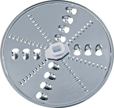 A close-up, top-down view of a single metal disc with various holes and cutting edges, likely a food processor attachment.