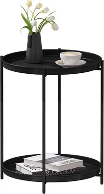 A black metal side table with two tiers, holding a vase of tulips and a cup of coffee on the top tier, and books on the bottom tier.