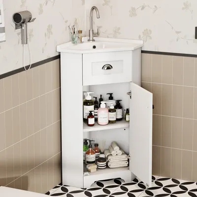 A white corner vanity cabinet with a sink and faucet, filled with various toiletries and towels, in a bathroom setting.