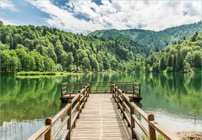 Produktbild von Wallario Fototapete Vliestapete, seidenmatte Oberfläche, einfache Verarbeitung, Größe 200 x 140 cm, Motiv Steg am See in den Bergen