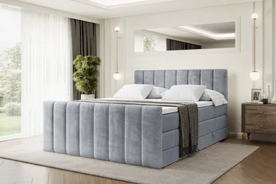 A bedroom with a large gray upholstered bed.