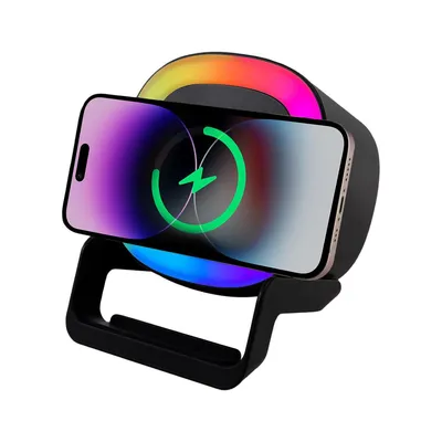 A smartphone is placed on a wireless charging stand with integrated RGB lighting.