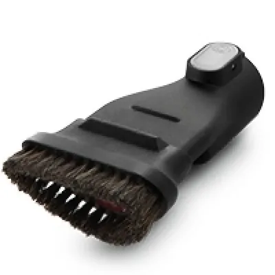 A black vacuum cleaner attachment with brown bristles is shown against a white background.