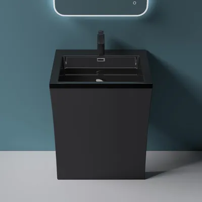 A modern black pedestal sink with a faucet against a blue wall.