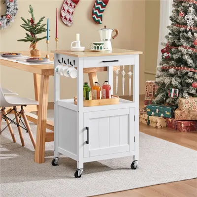A kitchen cart is shown next to a dining table and a Christmas tree, decorated for the holidays.