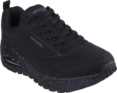 A black Skechers sneaker with a speckled sole is shown against a white background.