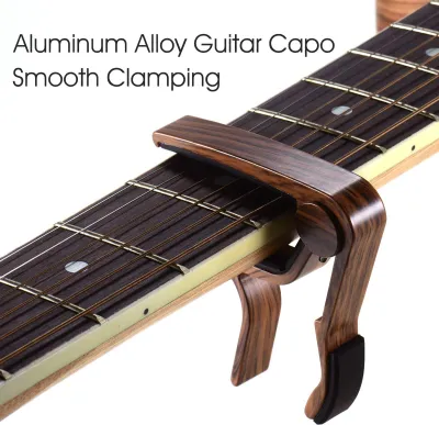 Produktbild von Kapodaster für Gitarre aus Aluminiumlegierung, Holzfarbe, für 6-saitige Folk-E-Gitarre mit 3 zufälligen Plektren