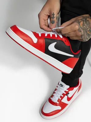 A person tying the laces of a pair of Nike Ebernon Premium sneakers.