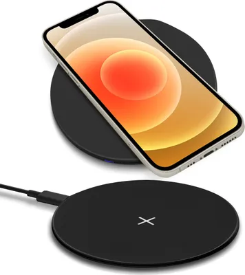 A smartphone is placed on a wireless charger, with another wireless charger connected to a cable in the foreground.