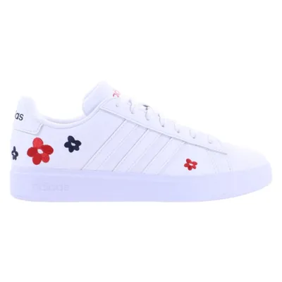 A side view of a white Adidas sneaker with red and blue floral accents.