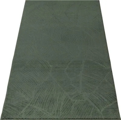 A green rug with a leaf pattern is shown from a slightly elevated angle against a white background.