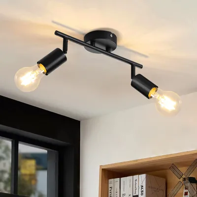 A black ceiling light fixture with two adjustable spotlights, each with an exposed Edison-style bulb, mounted on a white ceiling.