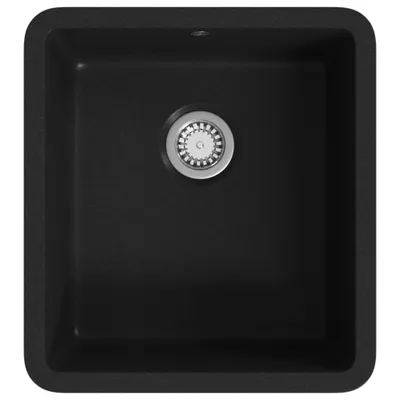 A top-down view of a black granite kitchen sink with a silver drain.