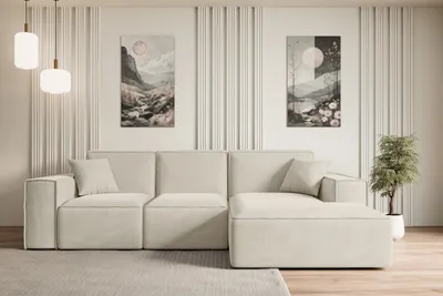 A modern living room with a beige sectional sofa, two pieces of abstract art on the wall, and a potted plant.