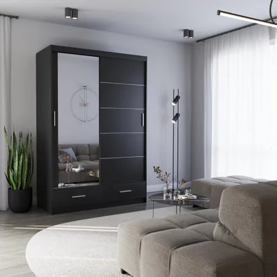 A modern bedroom or living room setting with a black sliding door wardrobe, a sofa, and a coffee table.