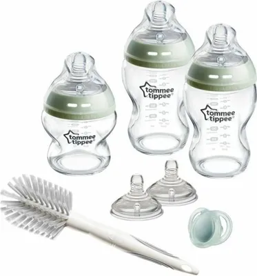 A set of baby bottles and accessories arranged on a white background.