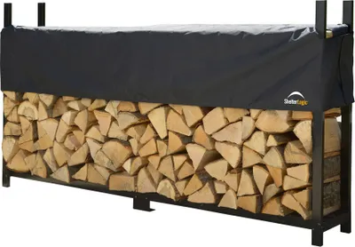 A firewood rack filled with logs and covered by a black tarp.
