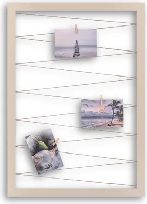 A beige picture frame with strings and clothespins holding up three small photos.