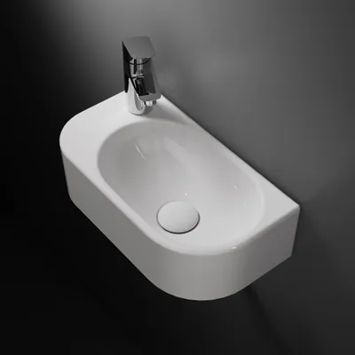 A white wall-mounted sink with a chrome faucet against a dark gray wall and black floor.