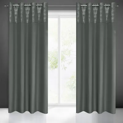 Two gray curtains with a geometric pattern at the top are hanging in front of a window.