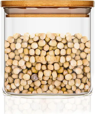 A glass storage jar filled with light-colored beans or seeds, topped with a bamboo lid.