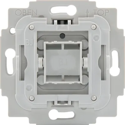 A close-up view of a light gray electrical switch insert, showing its internal mechanism and mounting points.