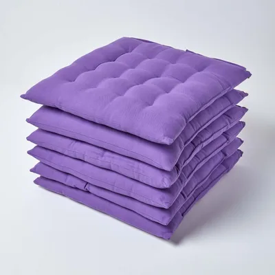 A stack of purple seat cushions on a white background.