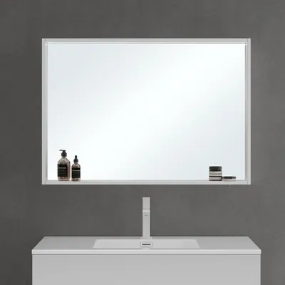 A modern bathroom vanity with a sink, faucet, and a large mirror above it. The mirror has a shelf with a few toiletries on it.