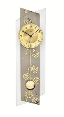 A wall clock with a pendulum and rose decoration.